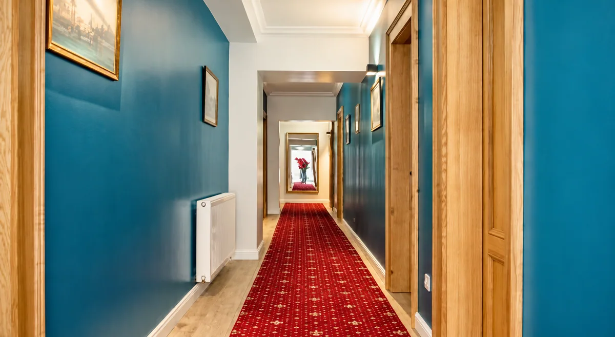 Holul English House, cu uși din lemn și covor roșu