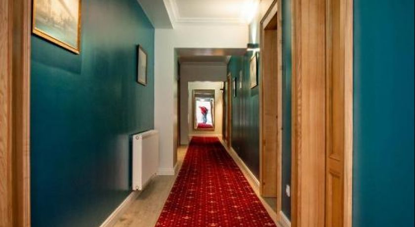 Holul English House, cu uși din lemn și covor roșu