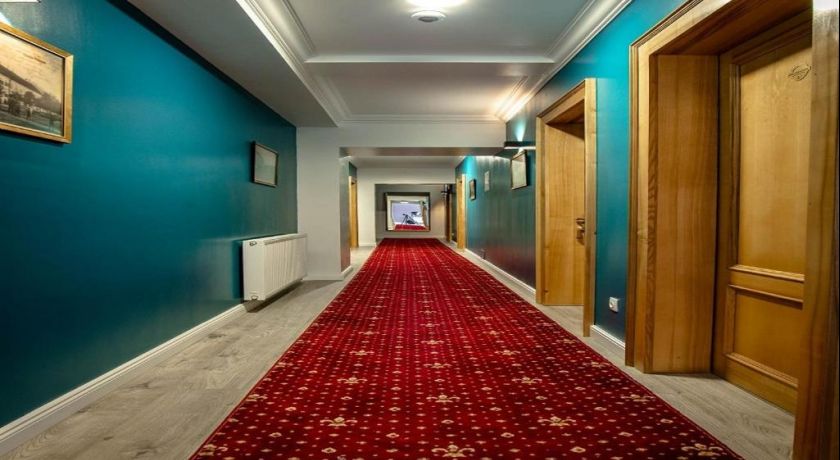 Holul English House, cu uși din lemn și covor roșu