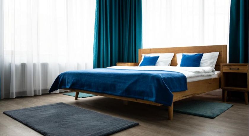 Dubla superioară 8, cu pat din lemn, textile albastre și ferestre luminoase